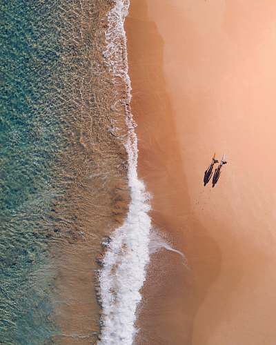 android wallpapers aerial photography of two persons walking along seashore during daytime android backgrounds